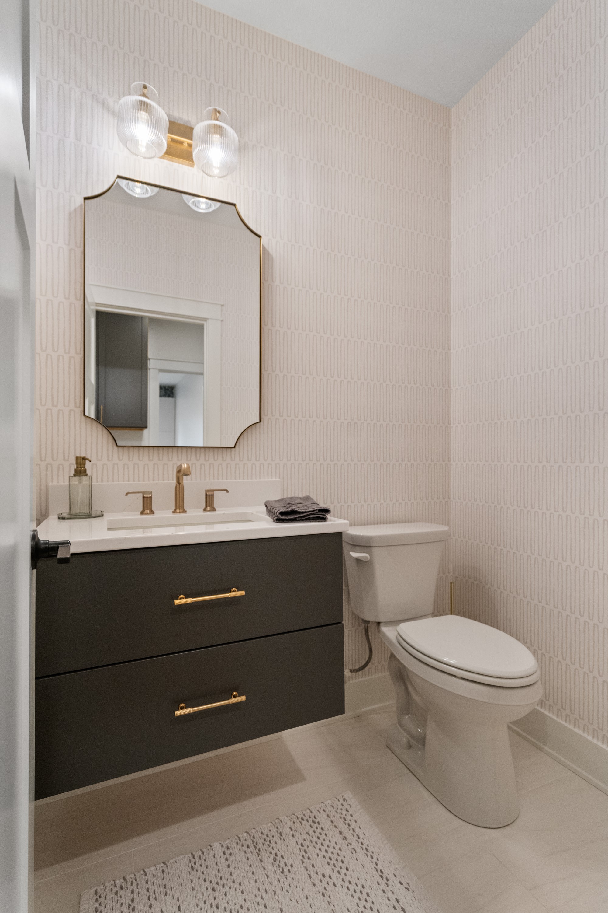 Powder room with designer wallpaper and floating vanity