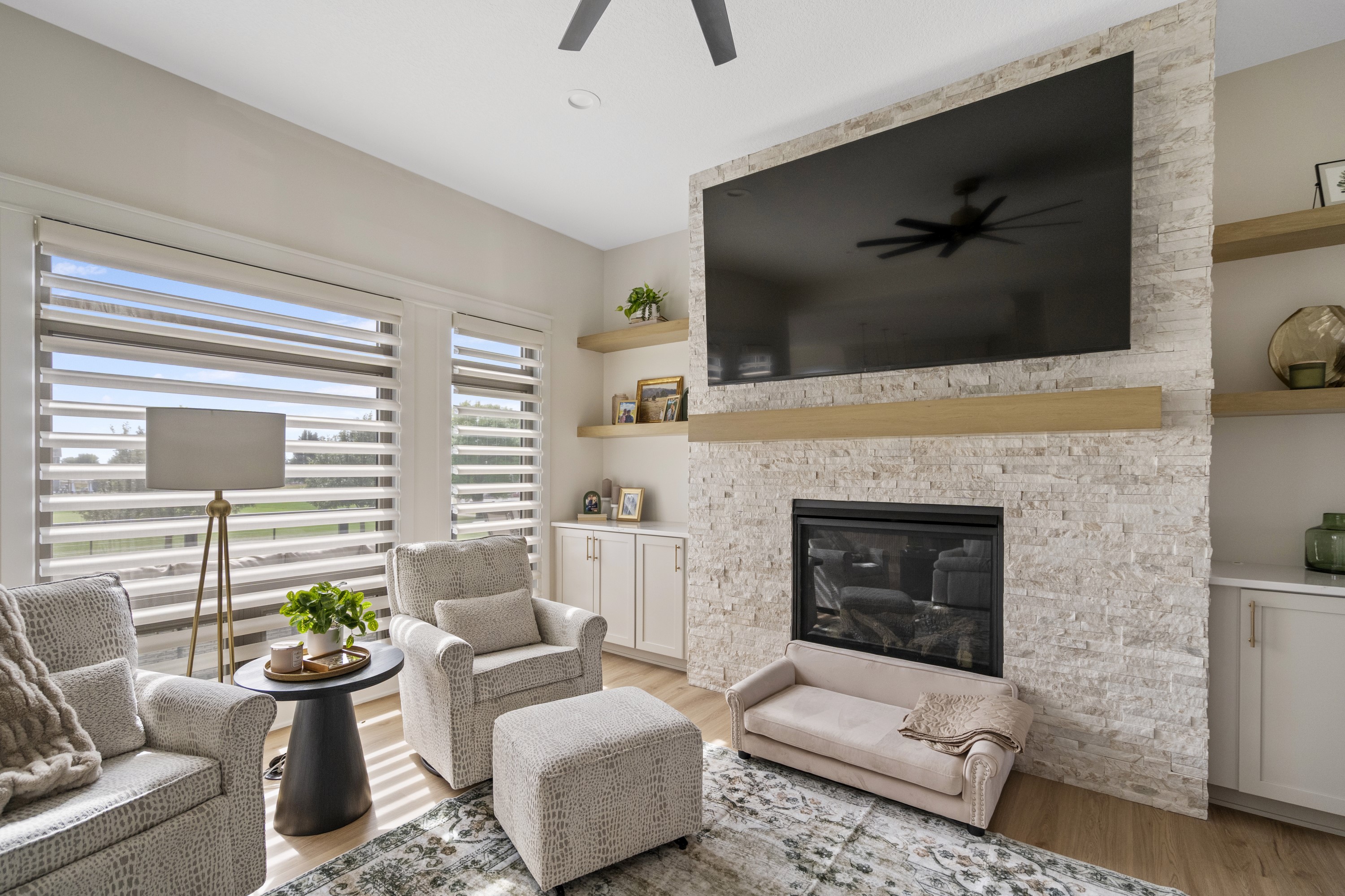 Living room with stone fireplace and built-in shelving
