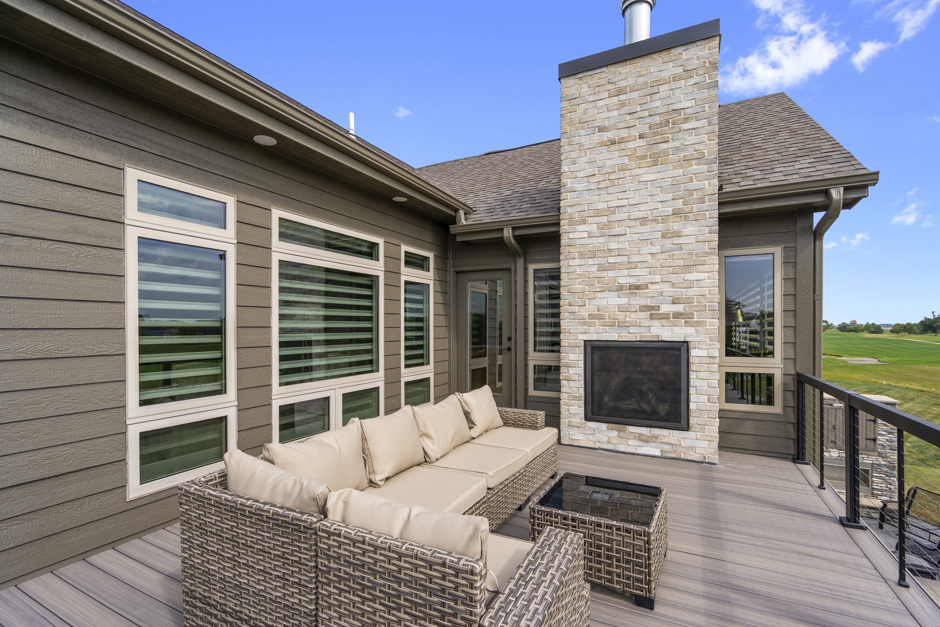 Outdoor living space with composite deck, outdoor fireplace, and comfortable seating area
