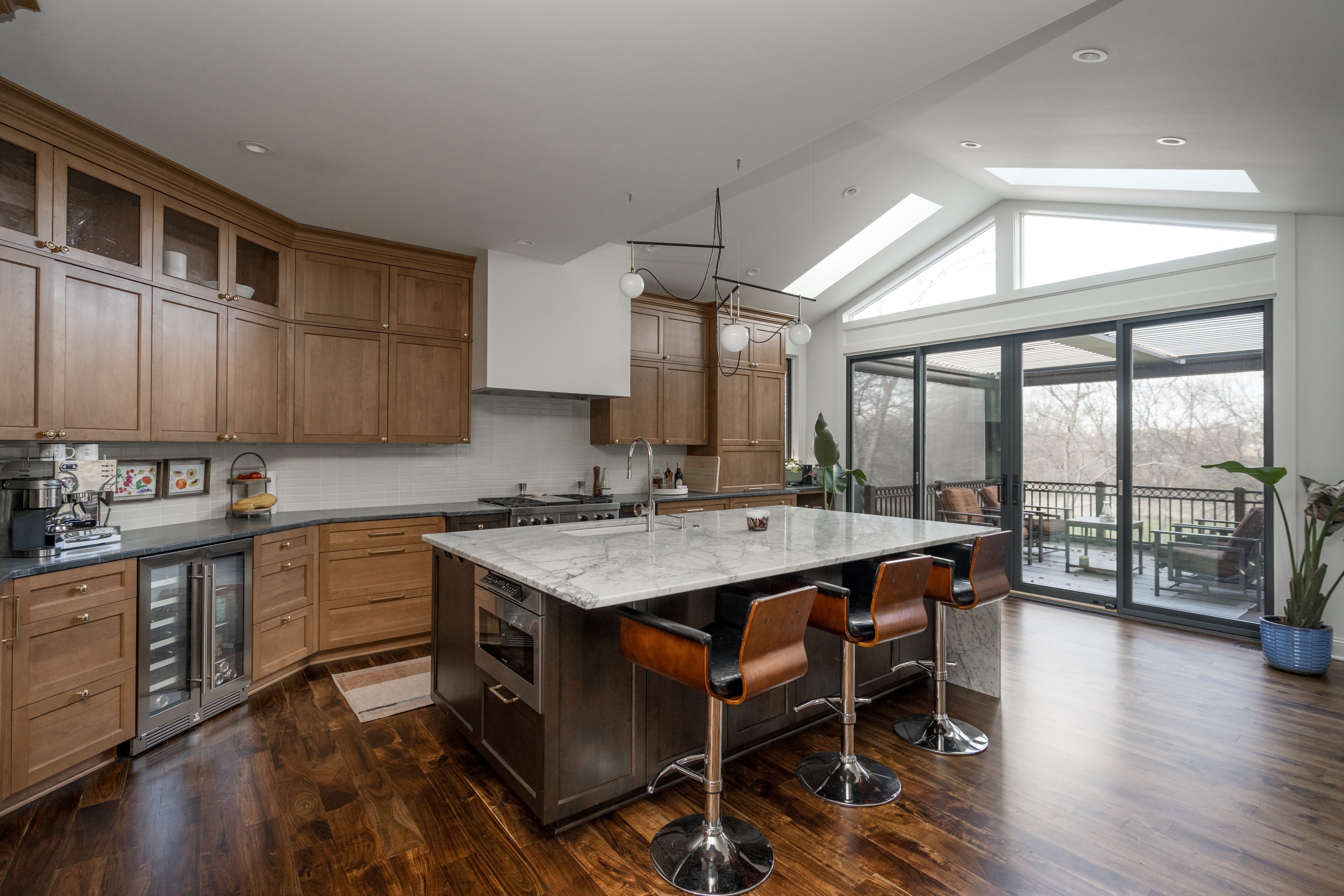 Open kitchen with custom wood cabinetry and marble island