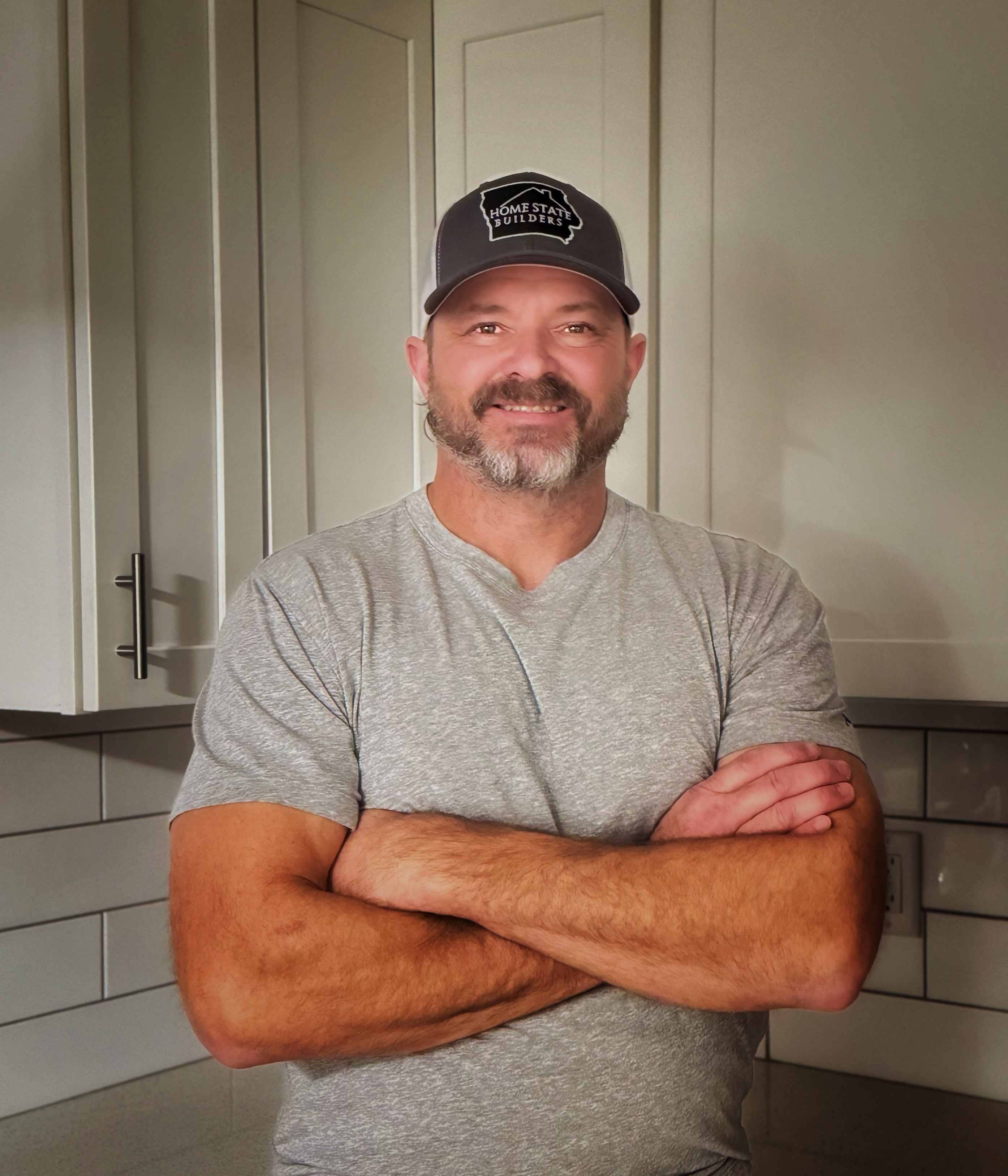 Tom Monson, Owner of Home State Builders, standing in a completed kitchen remodel